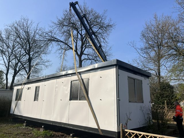 Stacaravan wordt met een kraan opgetild
